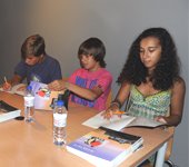 Os três protagonistas na sessão de autógrafos, que antecedeu a entrega de livros às crianças.